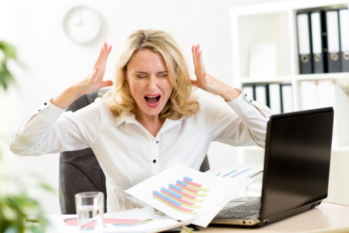 Stressed business woman at laptop in office